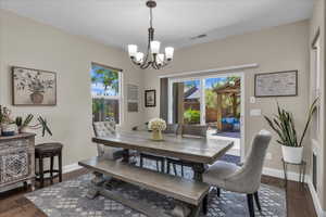 Dining area featuring dark wood-type flooring and a chandelier