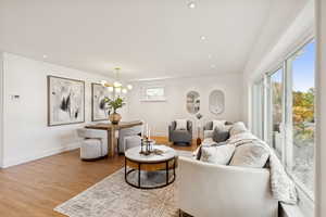 Living room featuring light wood-style flooring, recessed lighting, and a chandelier