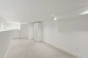 Empty room featuring light colored carpet and recessed lighting