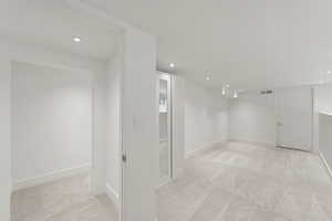 Below grade area with light carpet and recessed lighting