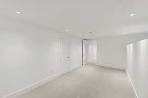 Empty room featuring light colored carpet and recessed lighting