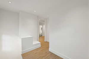 Hallway with recessed lighting and light wood-style floors