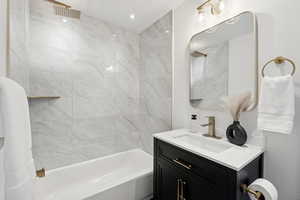 Bathroom featuring shower / bathtub combination with curtain and vanity