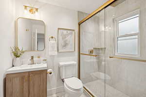 Bathroom featuring vanity and a marble finish shower