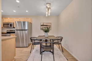 Dining space featuring recessed lighting, light wood-style flooring, and a chandelier
