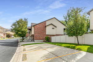 Side view of home with brick, siding, plenty of guest parking, and a mountain view