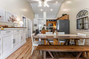 Dining area with high vaulted ceiling, light wood-type flooring, ceiling fan, and recessed lighting