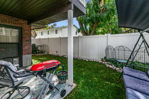 Private fenced backyard featuring a covered patio area