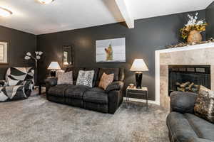 Living area featuring beamed ceiling and a gas log fireplace