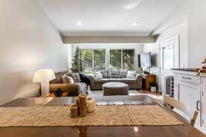 Living room featuring plenty of natural light, laminate wood  floors, vaulted ceiling, and recessed lighting