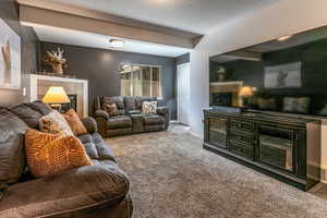 Living area with a tile fireplace and carpet floors