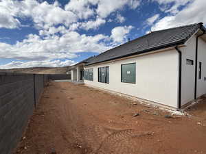 View of property exterior with a fenced backyard, stucco siding, and a patio area