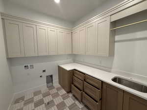 Laundry room featuring hookup for a gas dryer, hookup for an electric dryer, hookup for a washing machine, and cabinet space