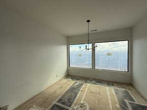 Unfurnished dining area featuring plenty of natural light and a chandelier