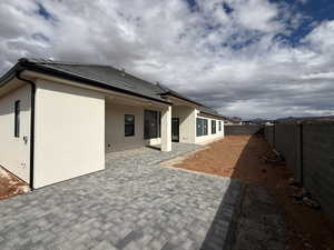 Back of house with a fenced backyard, a patio, and stucco siding