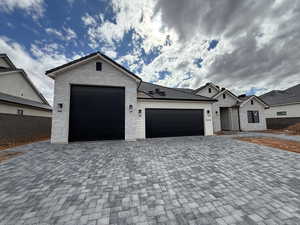 View of front of home featuring an attached garage and decorative driveway