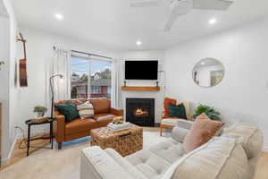 Living room with light wood-style flooring, a brick fireplace, and recessed lighting