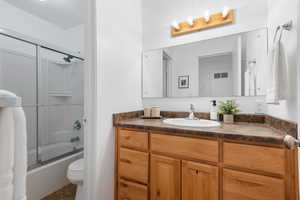 Full bathroom featuring shower / bath combination with glass door and vanity