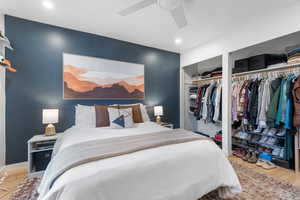 Bedroom featuring wood finished floors, ceiling fan, recessed lighting, and two closets