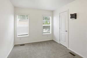 Spare room featuring light carpet and baseboards