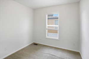 Empty room with carpet and baseboards