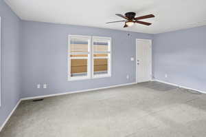 Spare room with light colored carpet and a ceiling fan