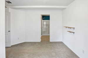 Unfurnished bedroom with light carpet and connected bathroom
