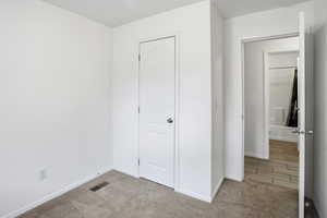 Unfurnished bedroom featuring carpet and a closet