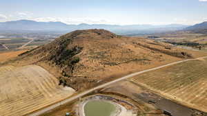 Aerial view of property and surrounding area featuring a mountainous background and rural landscape