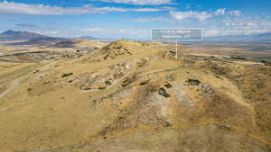 Aerial view of property and surrounding area featuring a mountain backdrop and rural landscape