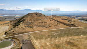 Aerial view of property and surrounding area featuring a mountainous background and rural landscape