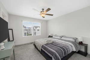 Carpeted bedroom featuring a ceiling fan and baseboards