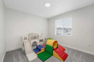 Recreation room with baseboards and carpet