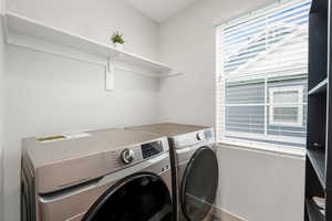 Washroom with washer and clothes dryer and baseboards