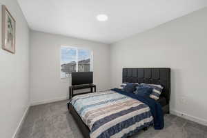 Bedroom featuring light carpet and baseboards