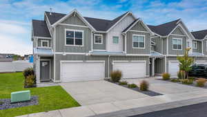 View of front of home featuring board and batten siding, concrete driveway, roof with shingles, a metal roof, and a residential view
