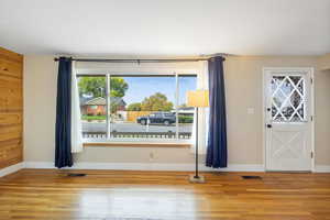Empty room featuring plenty of natural light and wood finished floors