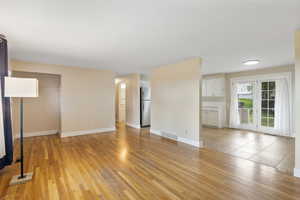 Unfurnished living room featuring light wood-style flooring and baseboards