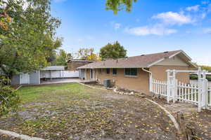 Back of property with a patio, brick siding, and a shingled roof