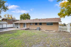 View of front of house with brick siding, a patio area, a chimney, and roof with shingles