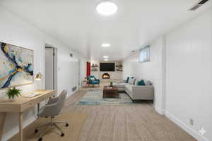 Digitally staged. Living room with light carpet, an office area, wood walls, and recessed lighting