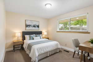 Digitally staged. Carpeted bedroom featuring baseboards