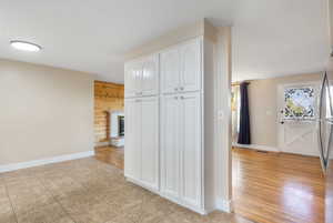 Hall with light tile patterned flooring and wood walls
