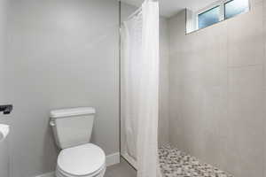 Bathroom featuring a shower stall and tile patterned flooring