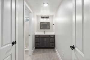 Full bathroom featuring a stall shower, vanity, a textured ceiling, and light tile patterned floors