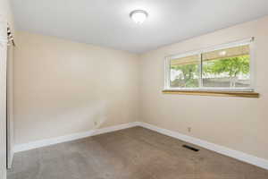 Empty room featuring carpet flooring and baseboards