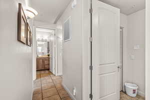Hallway with light tile patterned flooring and baseboards
