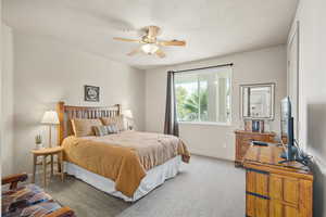 Carpeted bedroom featuring a ceiling fan and baseboards