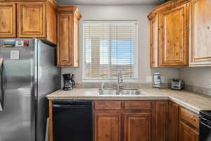 Kitchen with black appliances and brown cabinetry