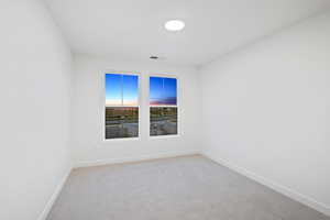 Unfurnished room featuring light colored carpet and baseboards